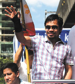 Seven-time world boxing champion Emmanuel Manny D. Pacquiao waves to well-wishers during a motorcade procession along the streets of Manila Nov. 20. -- <i>Reuters</i>
